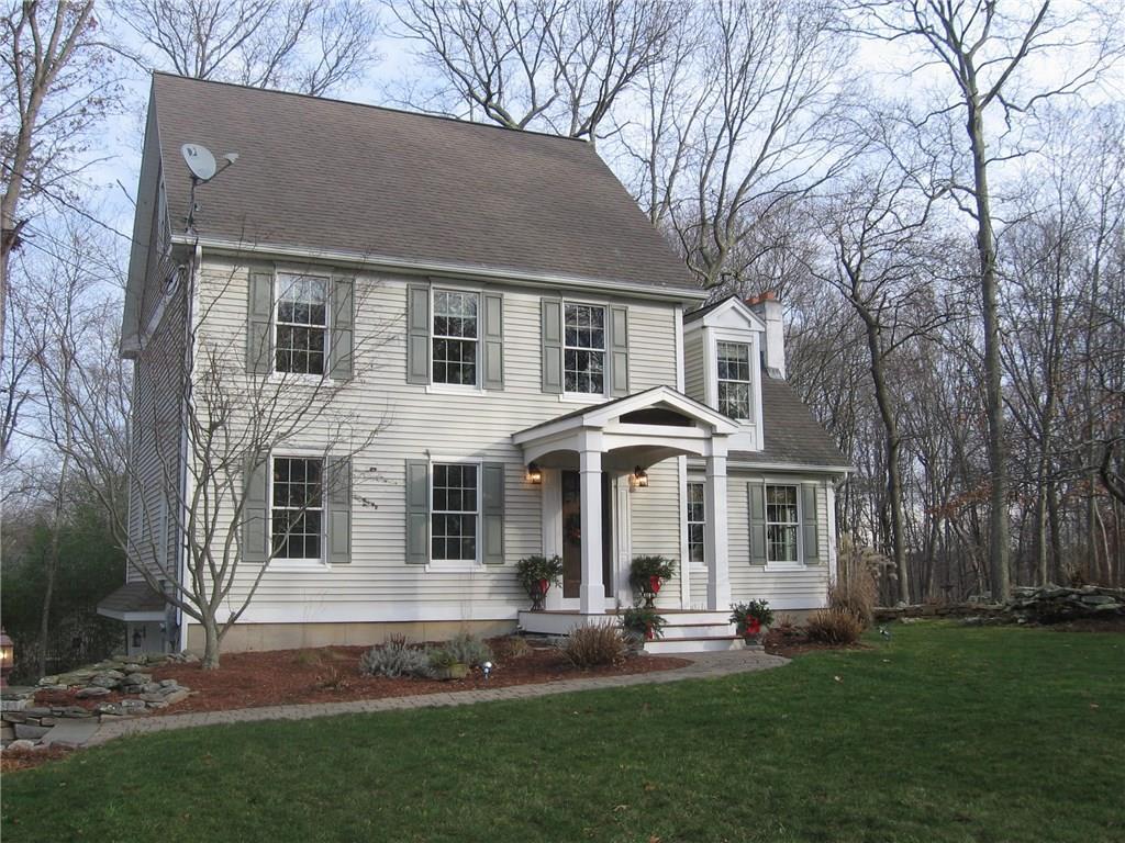 a front view of a house with a garden and trees
