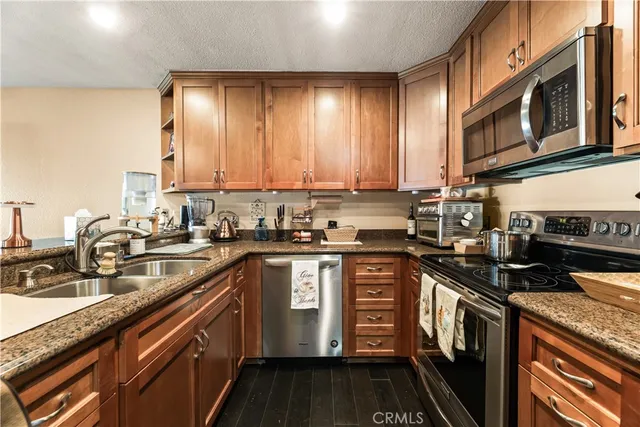 a kitchen with stainless steel appliances granite countertop a stove a sink and a microwave