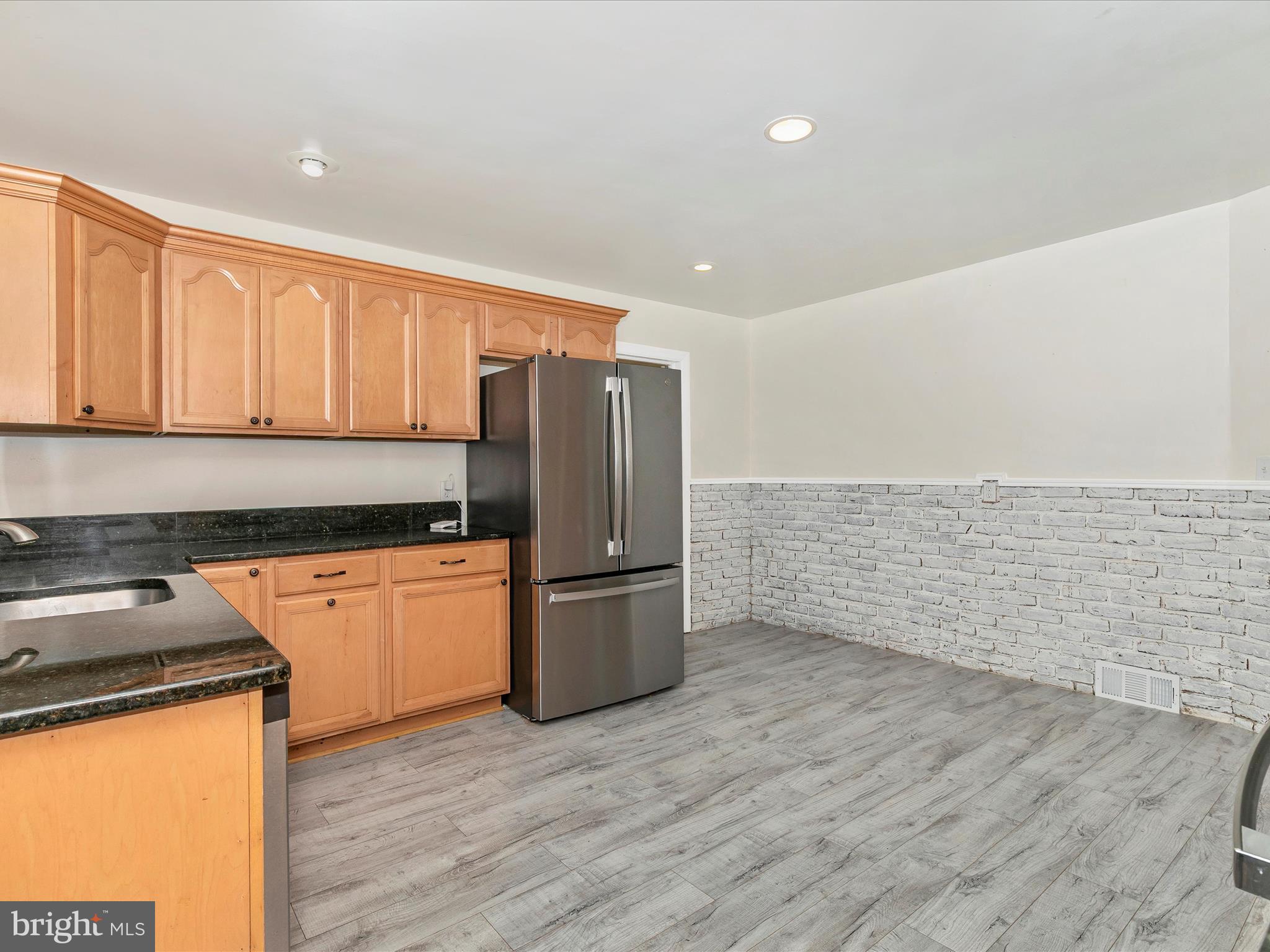 8913 Yellow Springs Road Frederick, MD 21702 - Photo 16 of 77 a kitchen with stainless steel appliances granite countertop a refrigerator a stove and a wooden floors