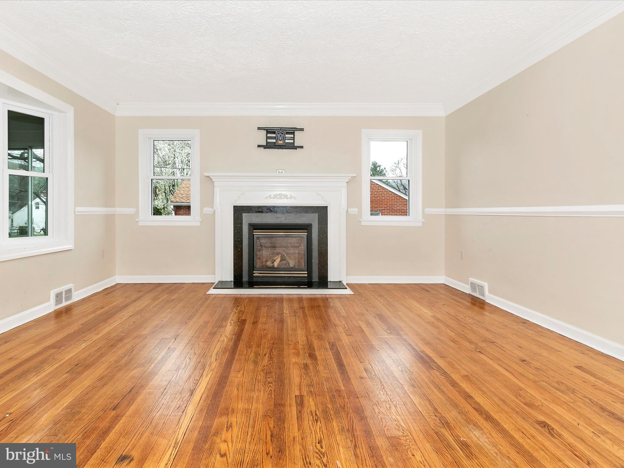8913 Yellow Springs Road Frederick, MD 21702 - Photo 4 of 77 an empty room with wooden floor fireplace and windows