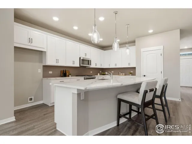 a kitchen with kitchen island granite countertop a sink a center island and appliances