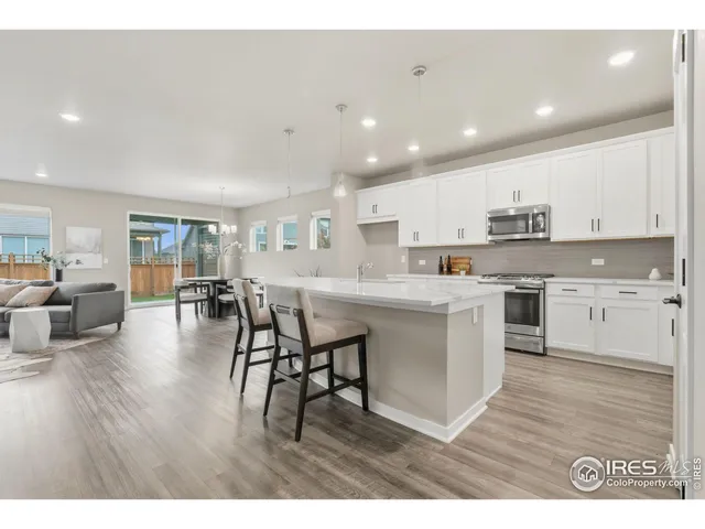 a kitchen with a table chairs refrigerator and cabinets