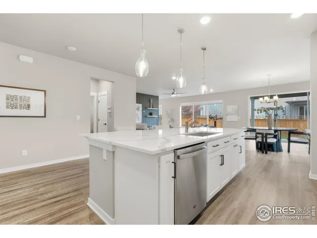 a kitchen with granite countertop a sink cabinets and wooden floor