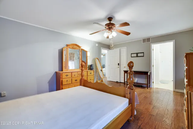 a bedroom with a bed a chandelier and dresser