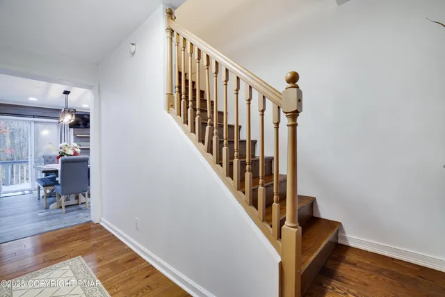 a view of hallway with wooden floor and stairs