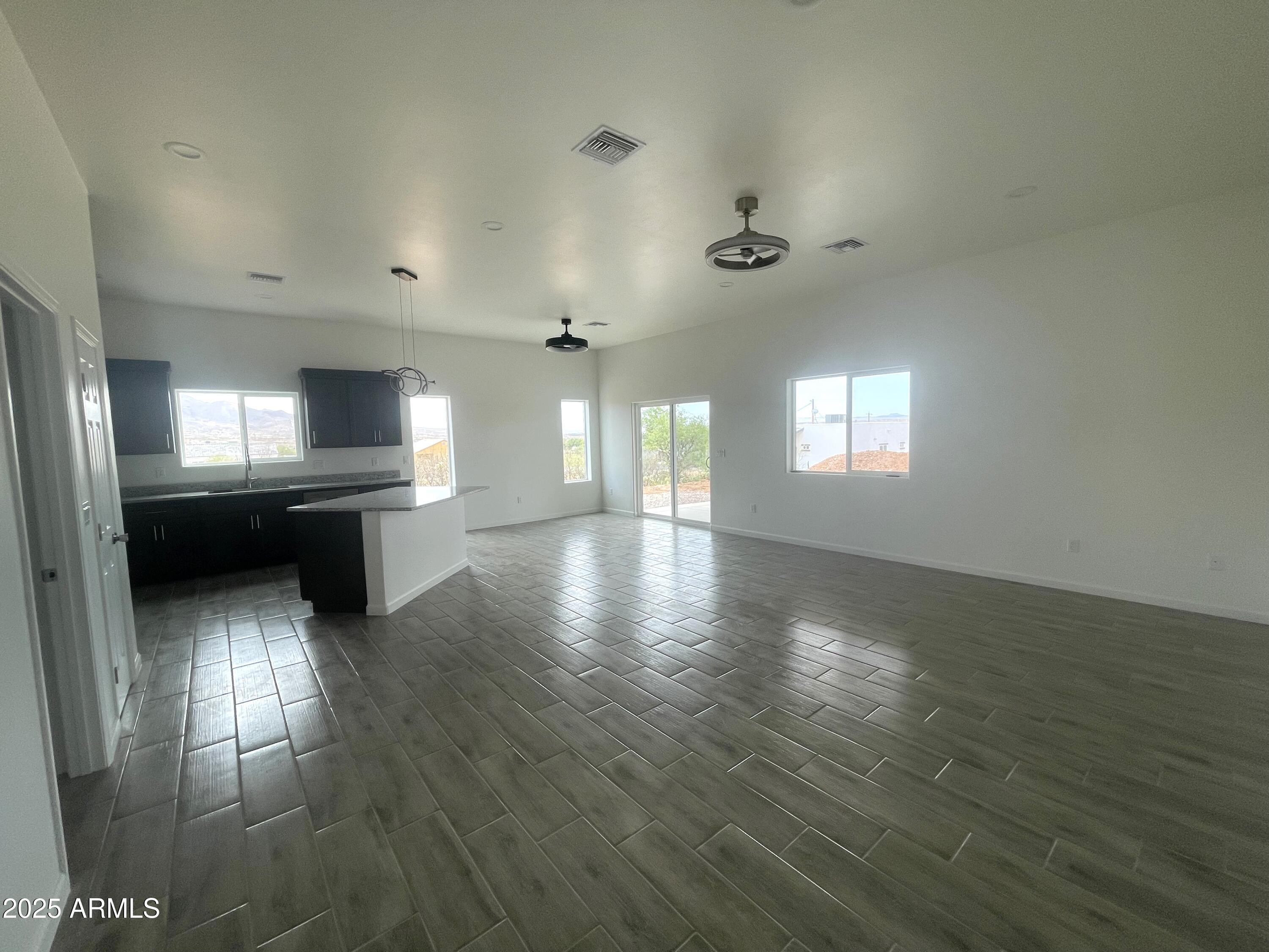 1825 Via Nueva Zelandia Rio Rico, AZ 85648 - Photo 7 of 20 an empty room with wooden floor and windows