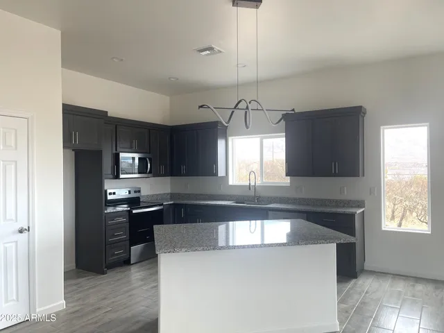 a kitchen with kitchen island a sink stainless steel appliances and window