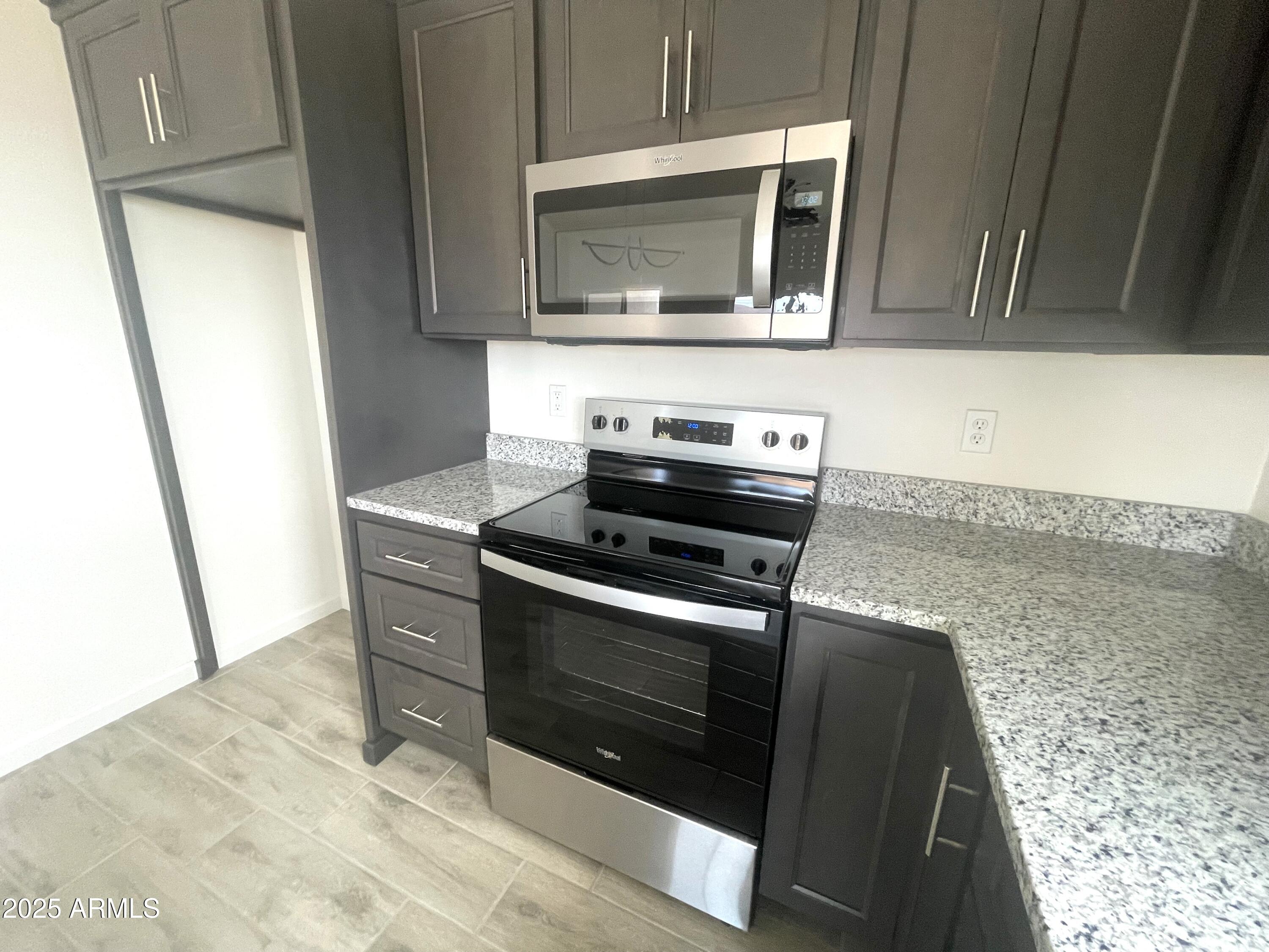 1825 Via Nueva Zelandia Rio Rico, AZ 85648 - Photo 9 of 20 a kitchen with granite countertop a stove and a microwave