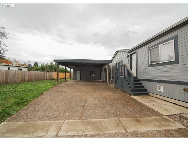 a pathway of a house with backyard and fence