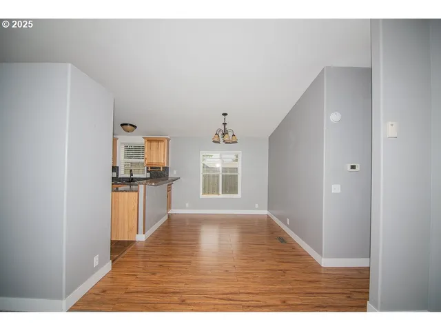 a kitchen with a refrigerator and a wooden floor
