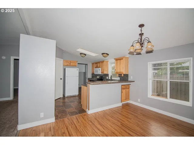 a kitchen with stainless steel appliances granite countertop a sink refrigerator stove and microwave