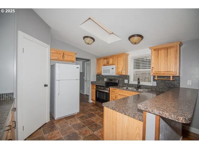 a kitchen with stainless steel appliances granite countertop a refrigerator and a sink