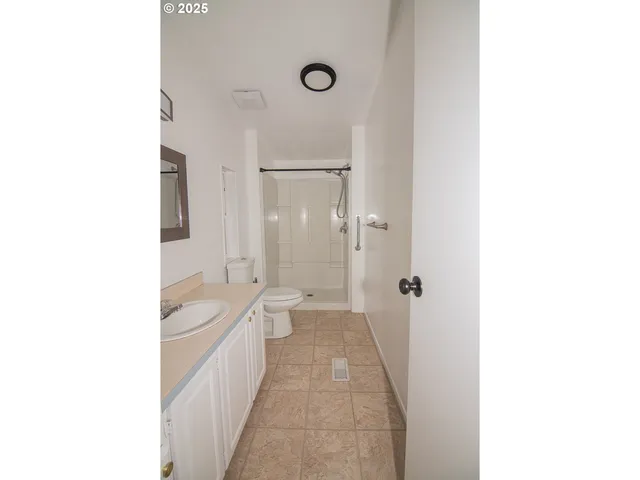 a bathroom with a toilet sink a shower and a mirror