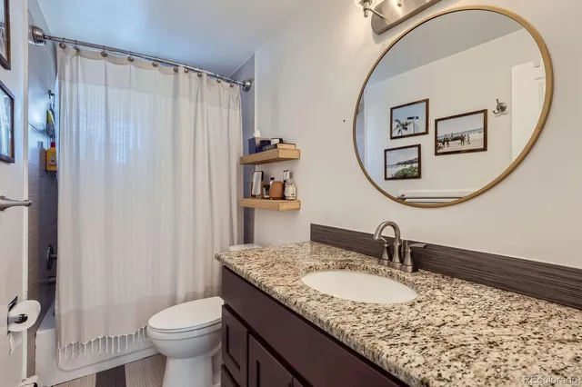 a bathroom with a granite countertop sink and a mirror