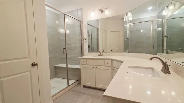 a bathroom with a sink tub shower and mirror