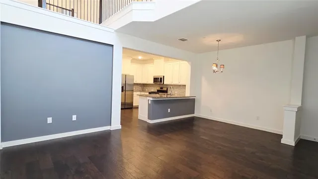 a view of a kitchen with a sink and dishwasher with wooden floor