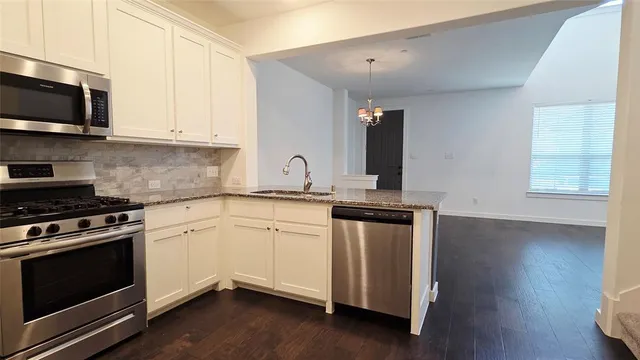 a kitchen with granite countertop a stove and a sink