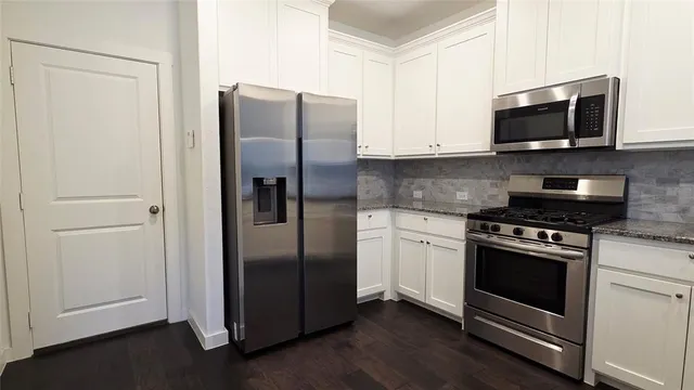 a kitchen with stainless steel appliances and wooden floor