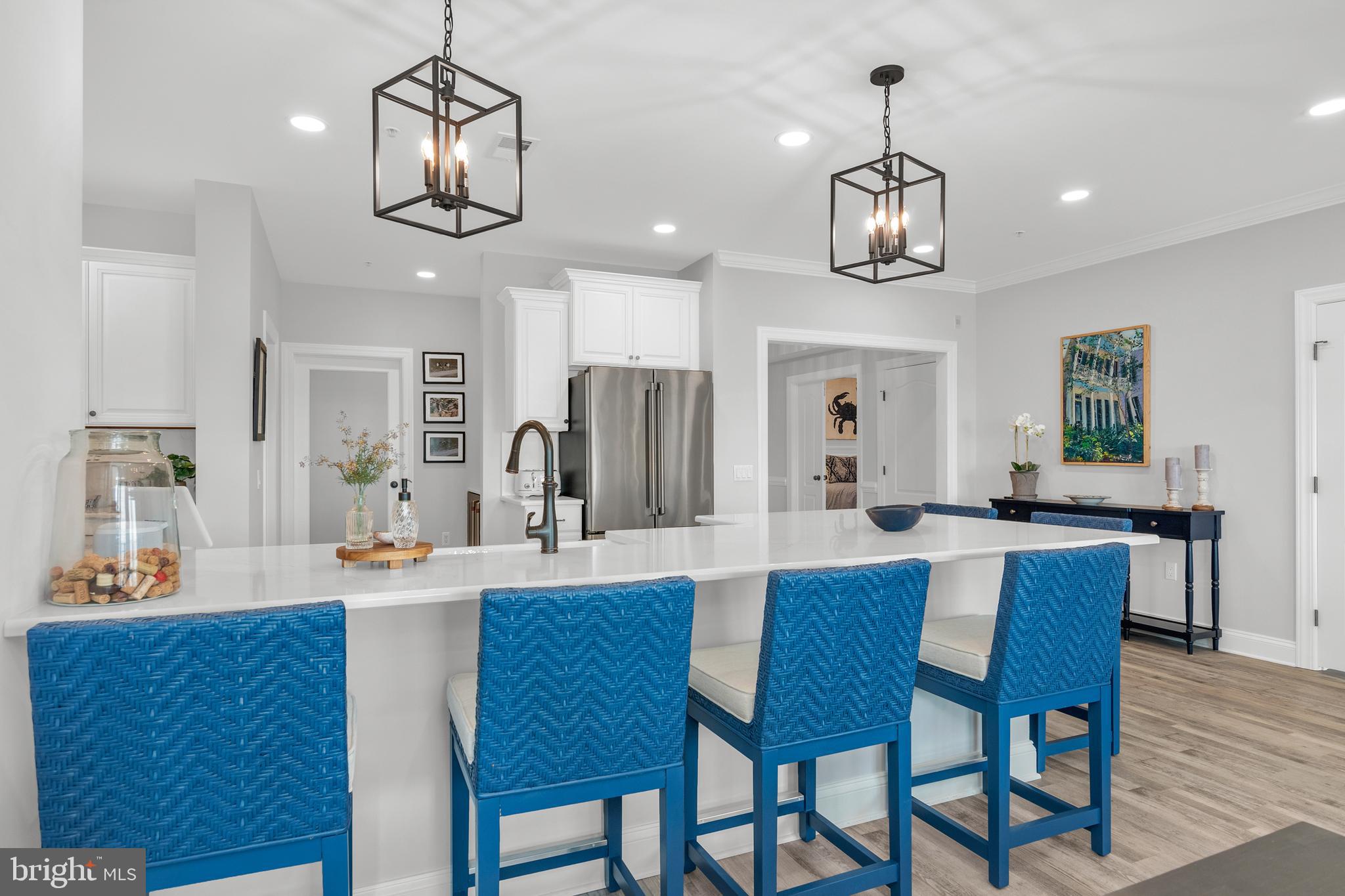301 Muir Street, Unit 303 Cambridge, MD 21613 - Photo 11 of 36 a large kitchen with a dining table and chairs