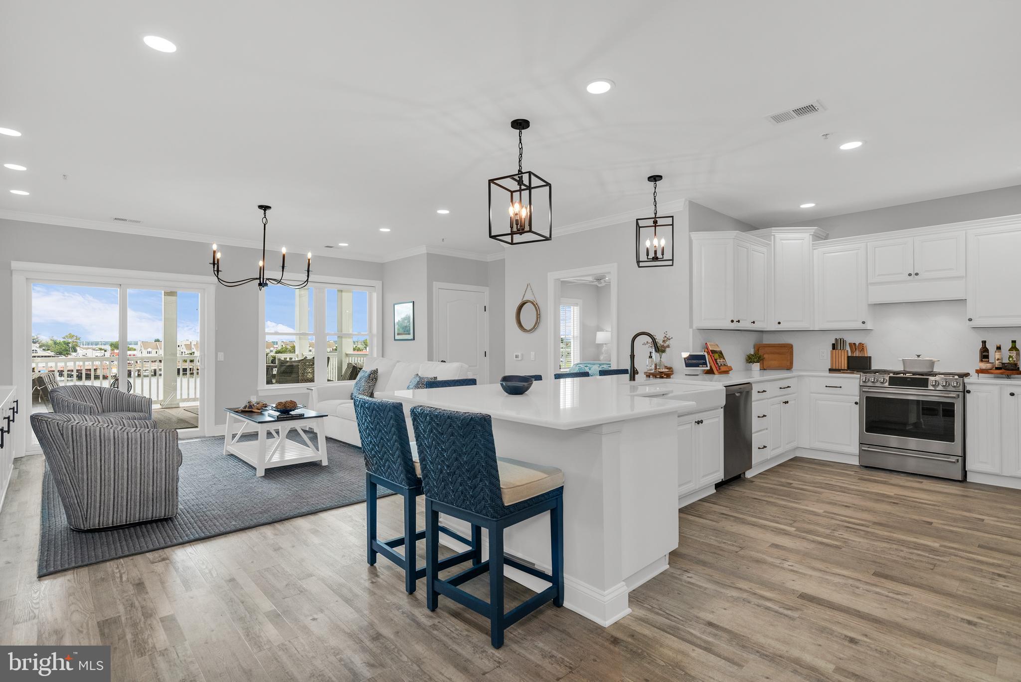 301 Muir Street, Unit 303 Cambridge, MD 21613 - Photo 14 of 36 a large kitchen with cabinets wooden floor and stainless steel appliances