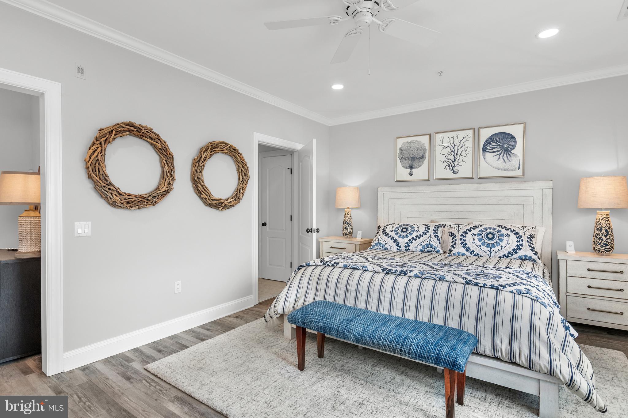 301 Muir Street, Unit 303 Cambridge, MD 21613 - Photo 21 of 36 a bedroom with a bed and a table in it