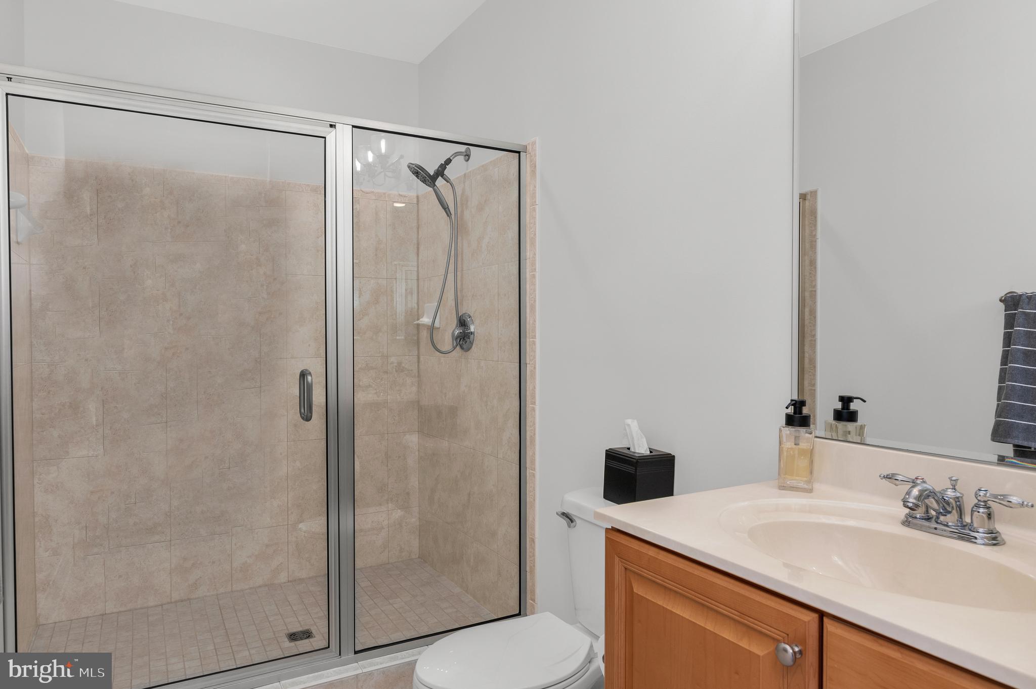 301 Muir Street, Unit 303 Cambridge, MD 21613 - Photo 25 of 36 a bathroom with a shower sink and mirror