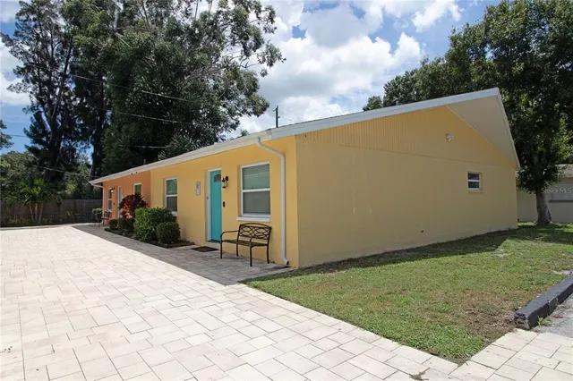 a backyard of a house with yard and large tree