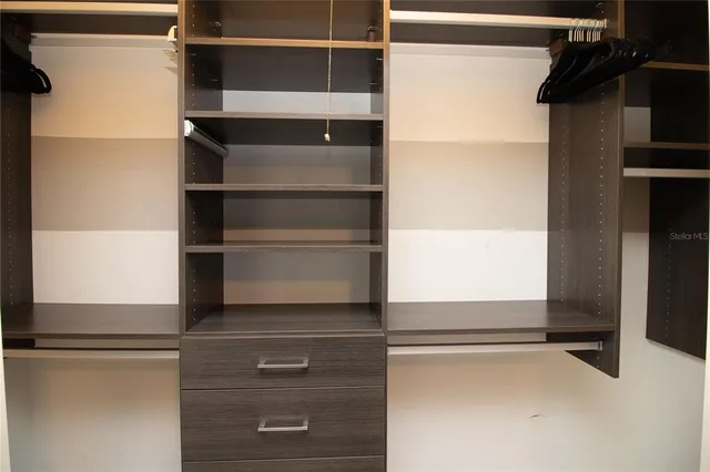 a bathroom with a granite countertop shower sink vanity and mirror