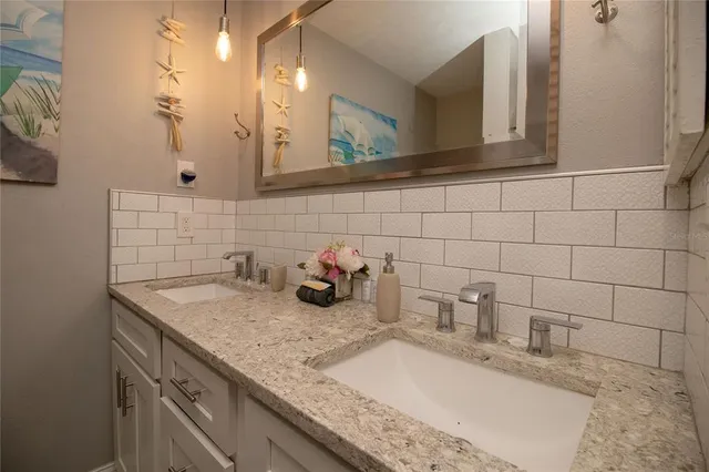 a bathroom with a granite countertop sink a mirror and vanity