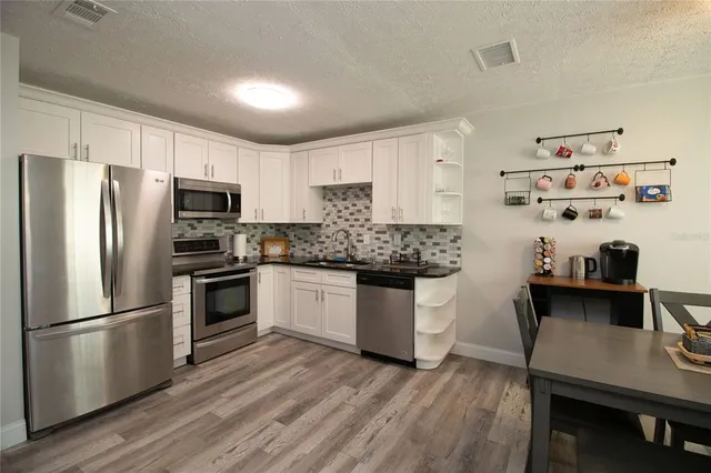 a kitchen with a refrigerator and white cabinets