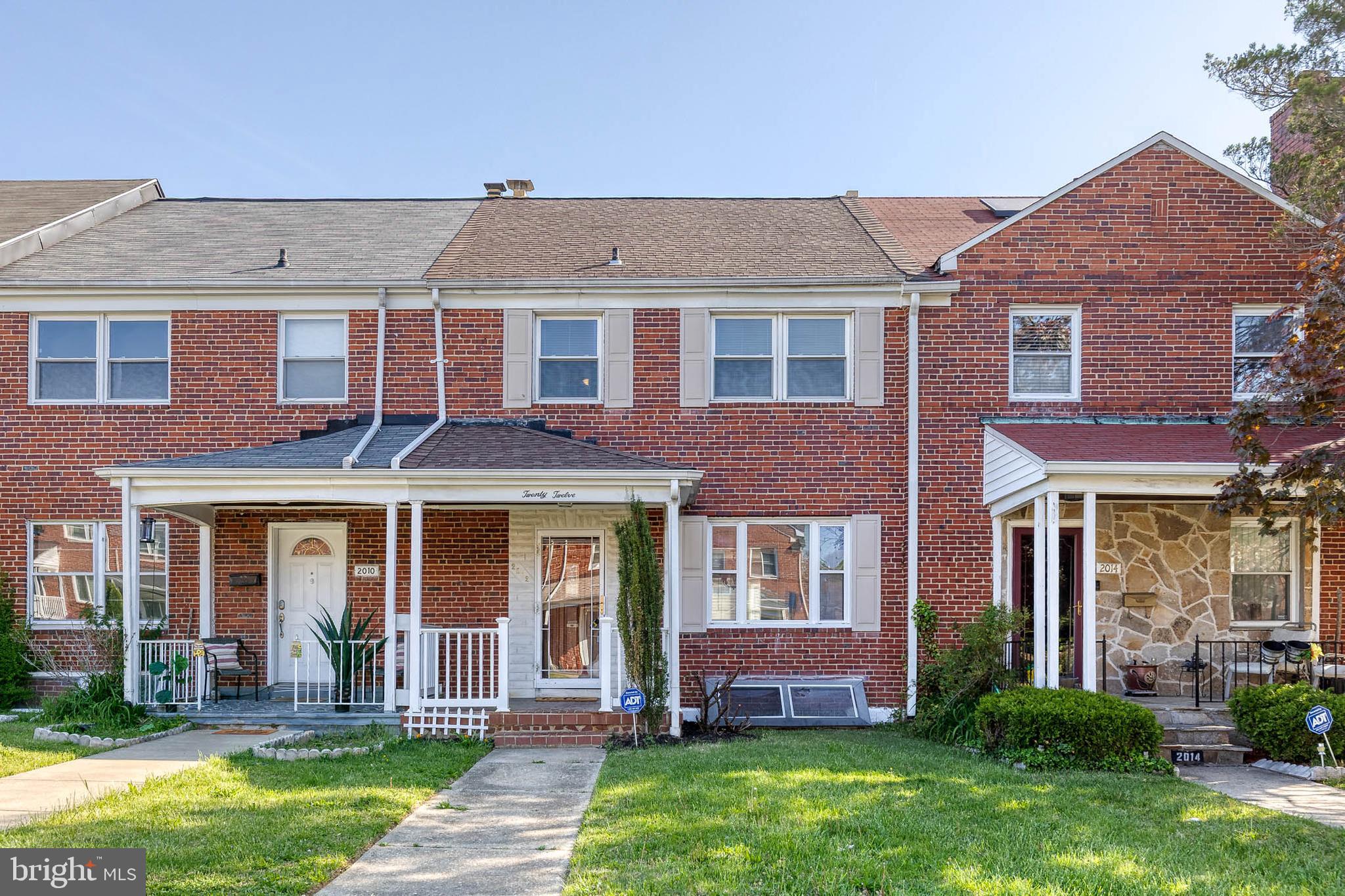front view of a brick house with a yard