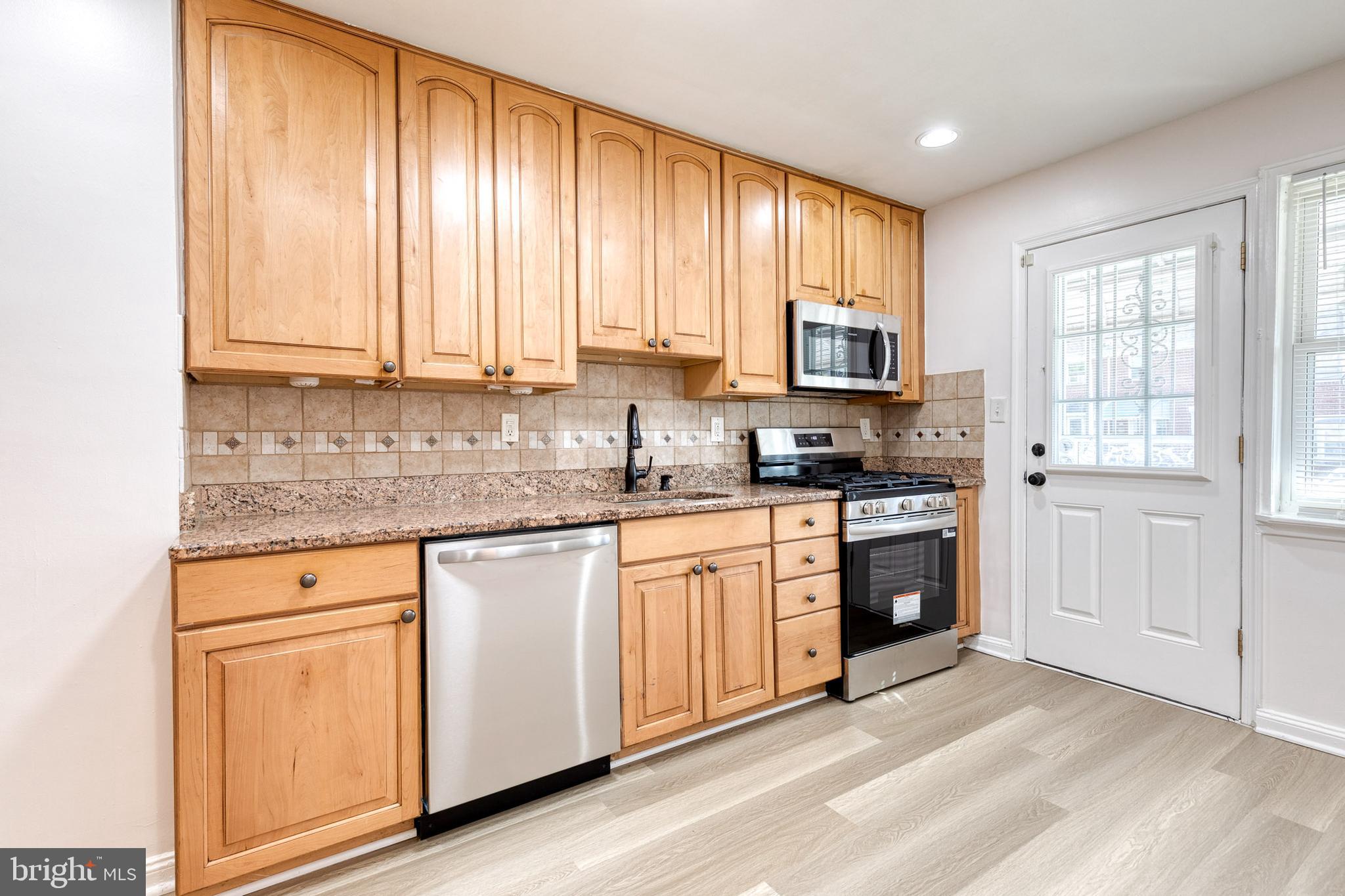 2012 Northbourne Road Baltimore, MD 21239 - Photo 17 of 35 a kitchen with stainless steel appliances granite countertop a stove a sink and white cabinets