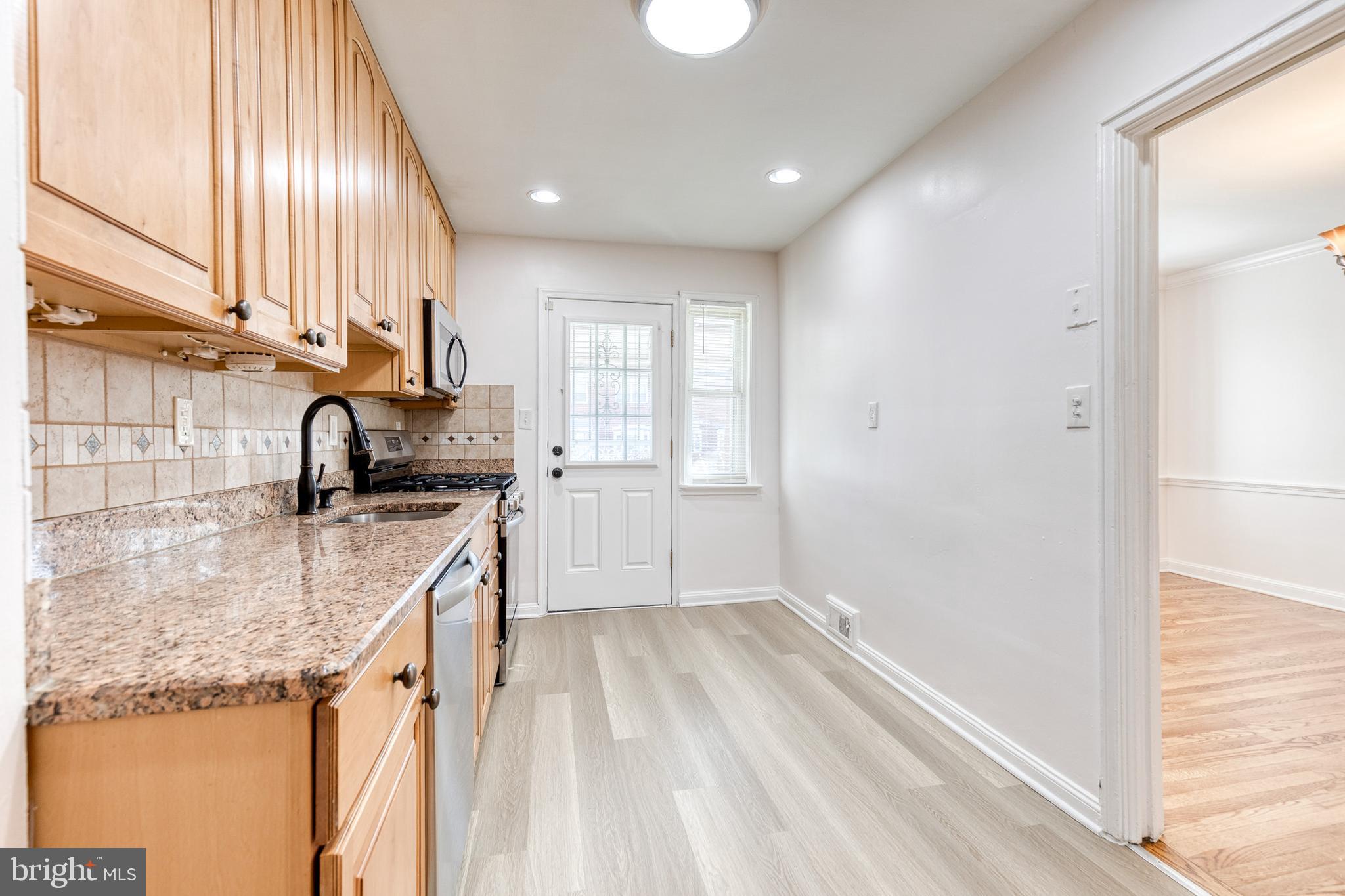 2012 Northbourne Road Baltimore, MD 21239 - Photo 20 of 35 a kitchen with a sink a counter top space cabinets and a window