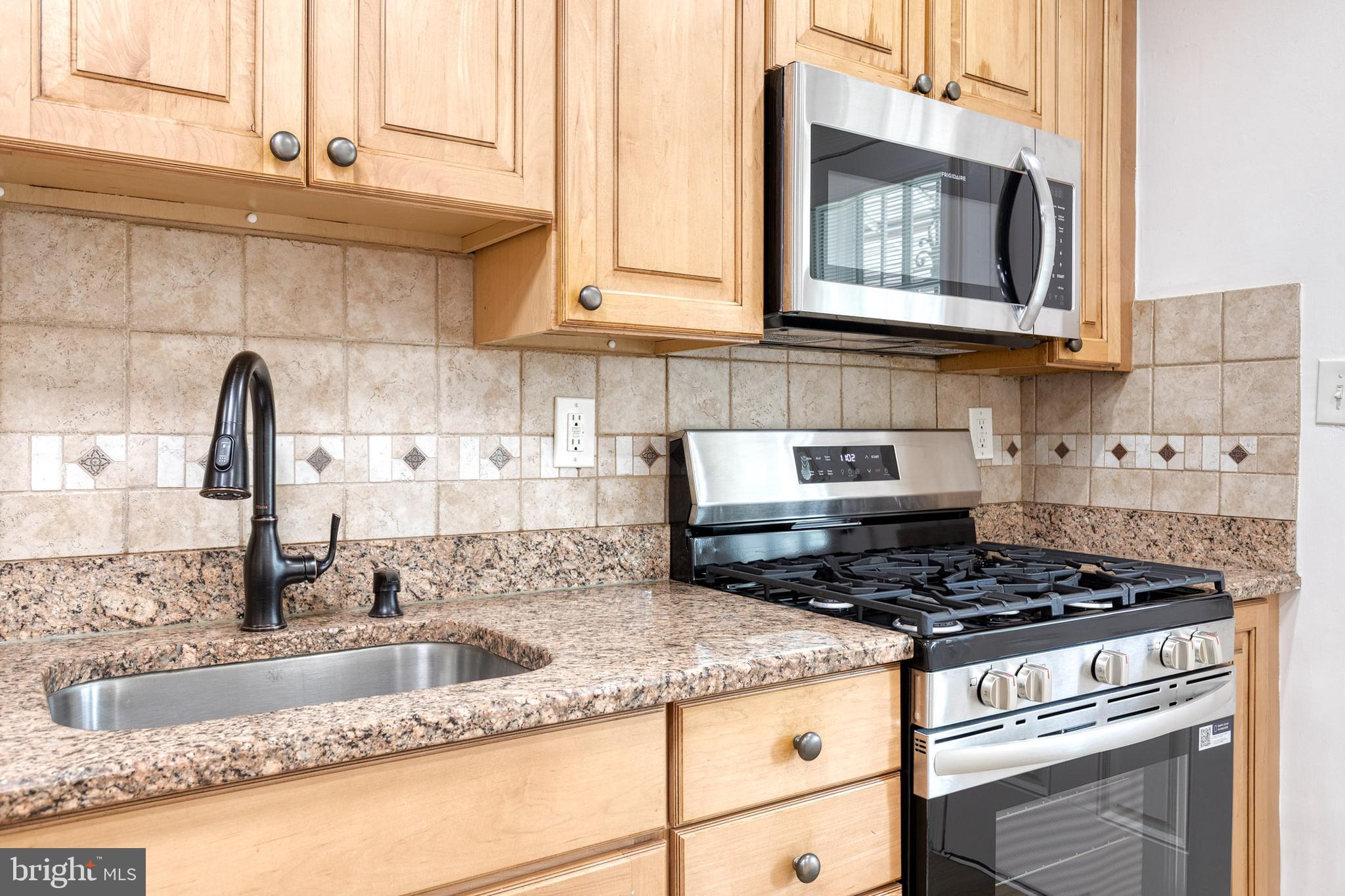 2012 Northbourne Road Baltimore, MD 21239 - Photo 22 of 35 a kitchen with granite countertop a sink a stove and cabinets