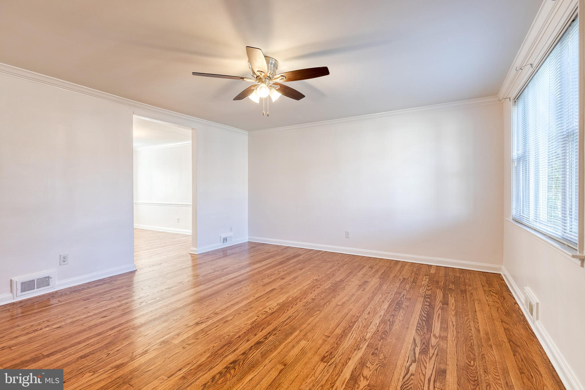 2012 Northbourne Road Baltimore, MD 21239 - Photo 4 of 35 an empty room with wooden floor fan and windows