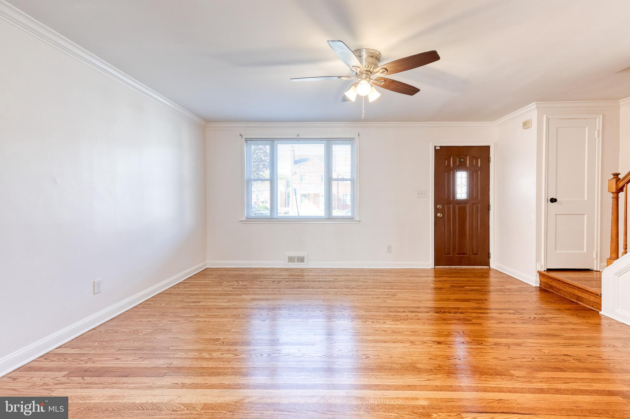 2012 Northbourne Road Baltimore, MD 21239 - Photo 9 of 35 an empty room with wooden floor chandelier fan and windows