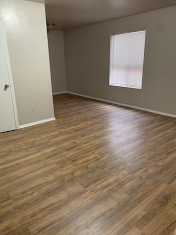 2701 Poplar Circle, Unit C Bryan, TX 77801 - Photo 2 of 8 an empty room with wooden floor and windows