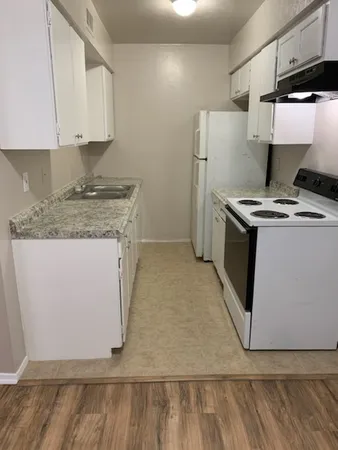 a kitchen with a stove and a white refrigerator