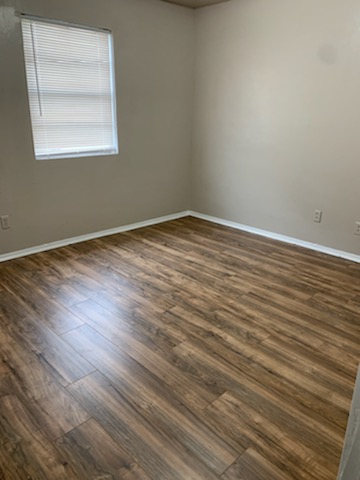 2701 Poplar Circle, Unit C Bryan, TX 77801 - Photo 5 of 8 a view of an empty room with wooden floor and a window