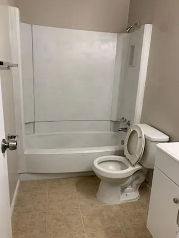 a bathroom with a granite countertop toilet a sink and a shower