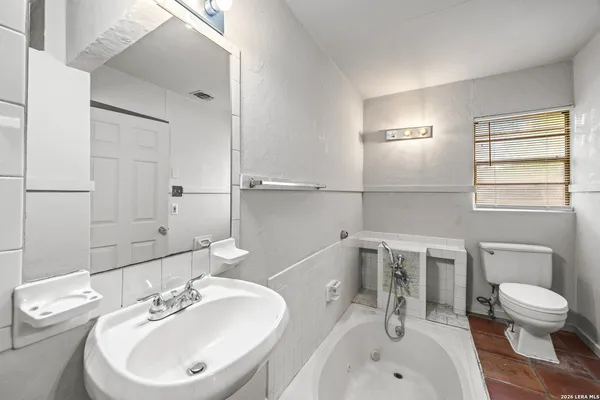 a bathroom with a sink a toilet and mirror