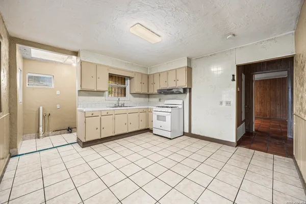 a kitchen with a cabinets a sink a window and stainless steel appliances