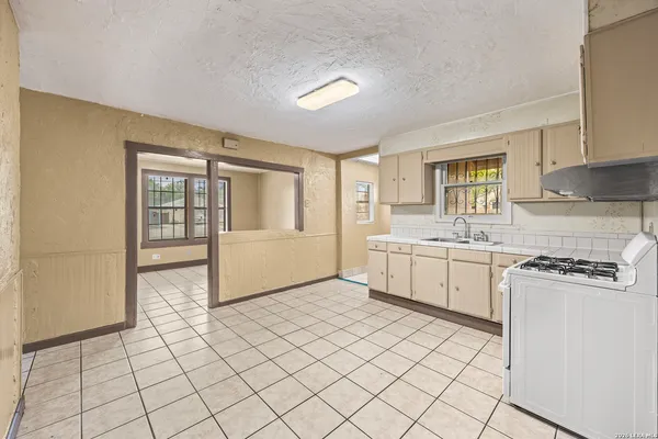 a kitchen with a stove a sink and cabinets