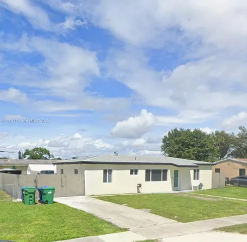 a aerial view of a house next to a big yard and large trees