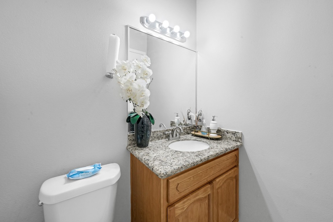 15711 Edo Circle Houston, TX 77083 - Photo 10 of 19 a bathroom with a granite countertop sink a toilet and a mirror
