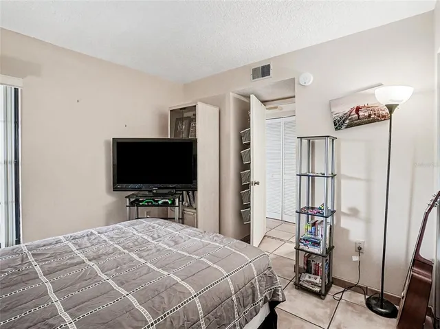 a bedroom with a bed and a flat tv screen on wall