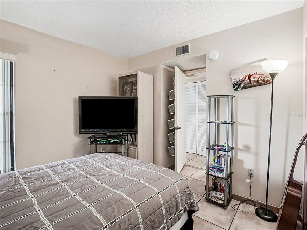 1052 Lotus Cove Court, Unit 733 Altamonte Springs, FL 32714 - Photo 17 of 28 a bedroom with a bed and a flat tv screen on wall