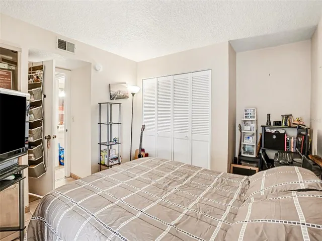 a bedroom with a bed a flat screen tv and a large mirror