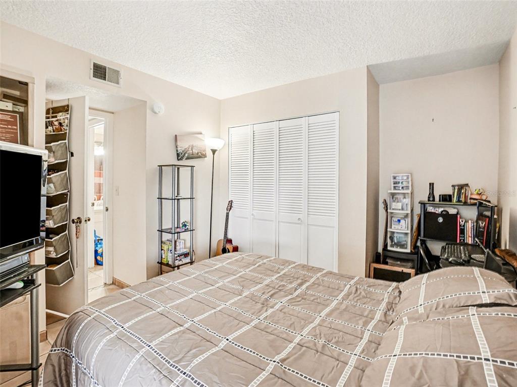 1052 Lotus Cove Court, Unit 733 Altamonte Springs, FL 32714 - Photo 18 of 28 a bedroom with a bed a flat screen tv and a large mirror