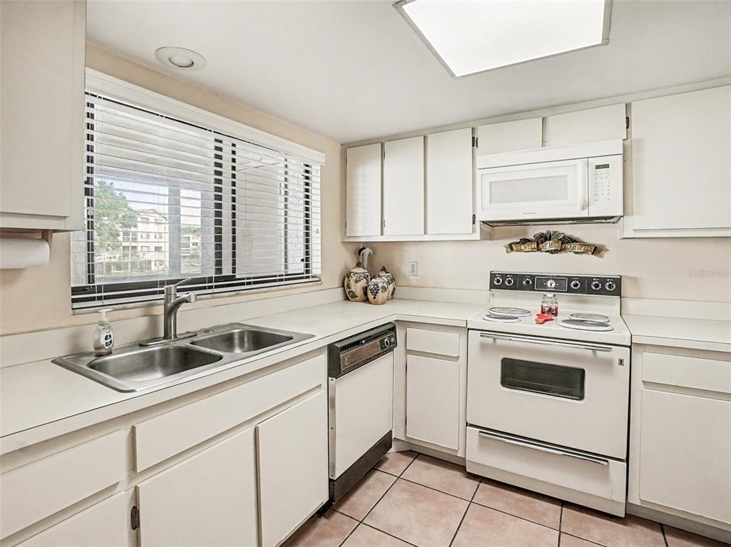 1052 Lotus Cove Court, Unit 733 Altamonte Springs, FL 32714 - Photo 10 of 28 a kitchen with white cabinets sink and white appliances